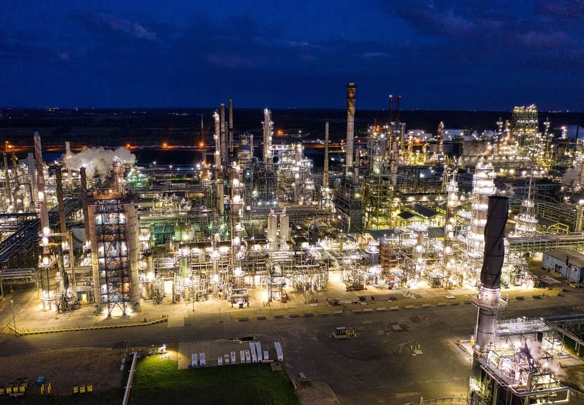Aerial view of a gas processing plant lit up at dusk